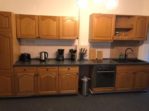 a kitchen with wooden cabinets and a stove top oven at Villa Schomberg in Spremberg