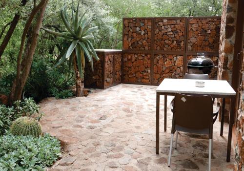 a patio with a table and chair and a fence at Waterside Cottages & Villas - Self Catering in Gaborone
