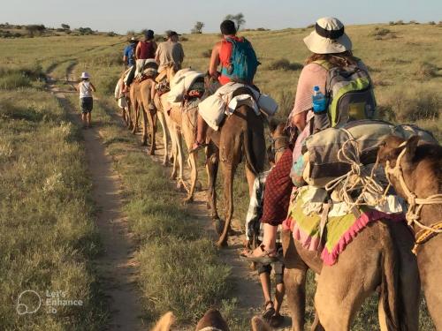 a group of people riding horses on a dirt road at Hotel Mirage in Jaisalmer