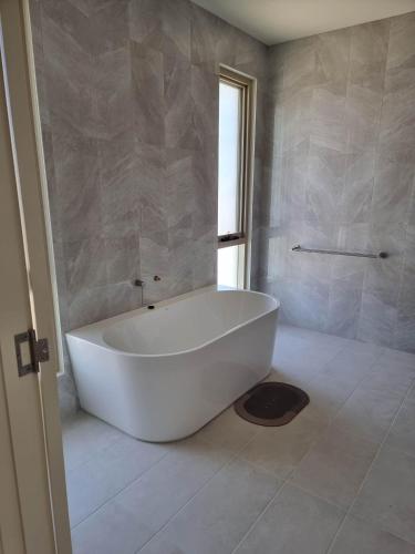 a white bath tub in a bathroom with a window at Koopalanda Dreaming in Vivonne Bay