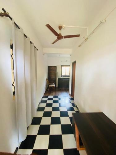 a room with a ceiling fan and a checkered floor at De Lavender Luxury sea view Guest Houses in Agonda