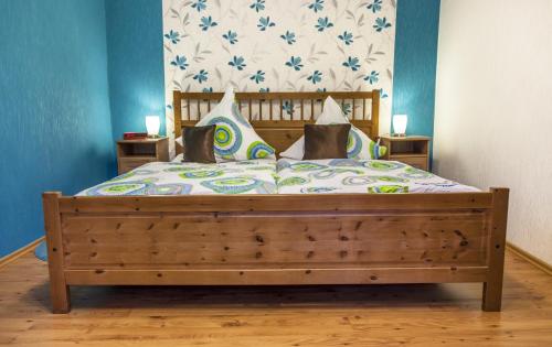 een slaapkamer met een groot bed met een houten frame bij Hotel-Gasthof Wilder Mann in Pfreimd