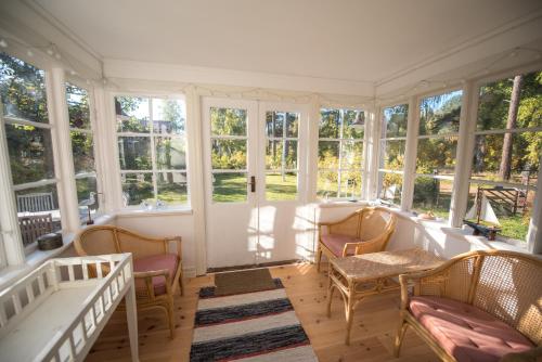 a screened in porch with chairs and windows at Huset Lövhyddan - SWEEDS Loftahammar in Loftahammar