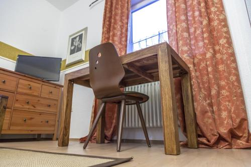 einen Schreibtisch mit einem Stuhl vor einem Fenster in der Unterkunft Hotel-Gasthof Wilder Mann in Pfreimd