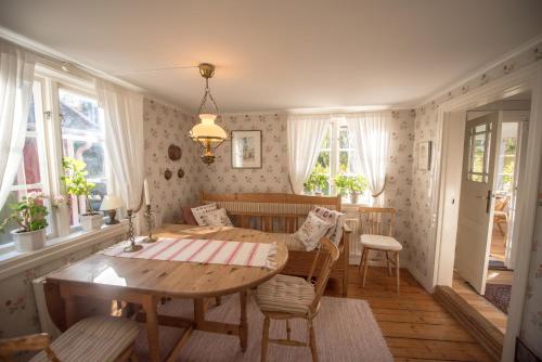 a dining room with a wooden table and chairs at Huset Lövhyddan - SWEEDS Loftahammar in Loftahammar