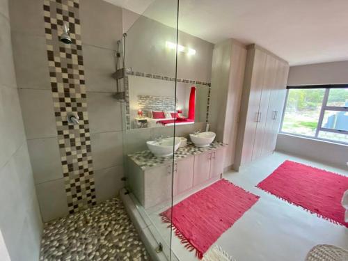 Baño con 2 lavabos y espejo en Grys Patrys - 4 Beds Beach Home, en Jeffreys Bay