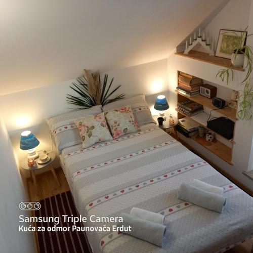 a small bedroom with a bed with two pillows at Holiday Home Paunovaca in Erdut