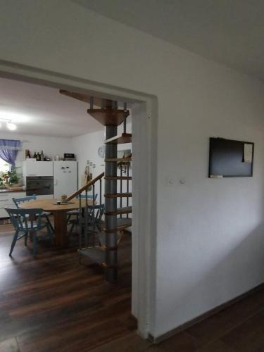 a living room with a table and a spiral staircase at Holiday Home Paunovaca in Erdut