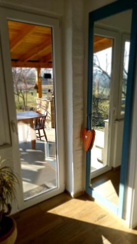 an open door of a house with a porch with a table at Holiday Home Paunovaca in Erdut
