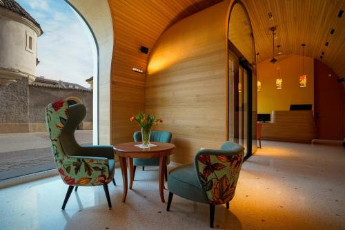 博爾扎諾的住宿－La Briosa，一间设有两把椅子、一张桌子和一面镜子的房间