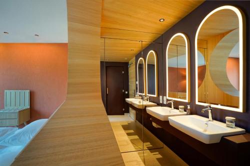 a bathroom with three sinks and two mirrors at La Briosa in Bolzano