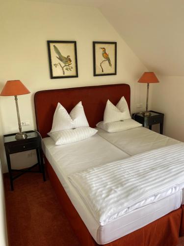 a bedroom with a large bed with two lamps on tables at Hotel Villa am Stadthafen in Neustrelitz