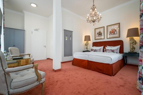 a bedroom with a bed and a desk and a chair at Hotel Villa am Stadthafen in Neustrelitz