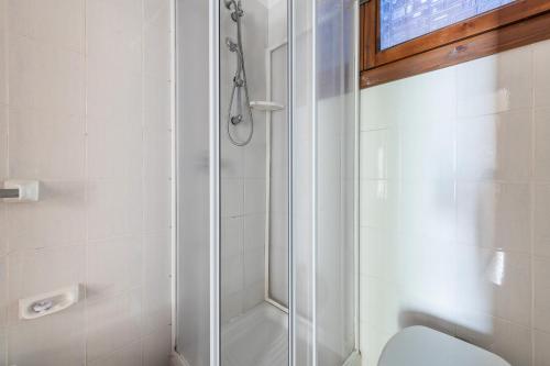 La salle de bains est pourvue d'une douche en verre et de toilettes. dans l'établissement Le Gemelle al 212, à Villaputzu