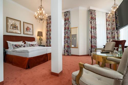 Hotel Villa am Stadthafen في نويشتريليتس: غرفة نوم بسرير وطاولة وكراسي
