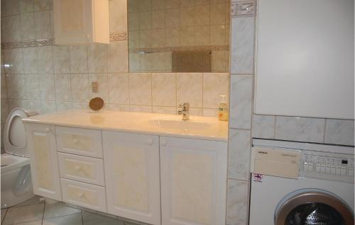 a bathroom with a sink and a washing machine at Holiday Home Vadgårdsvej in Nørre Nebel