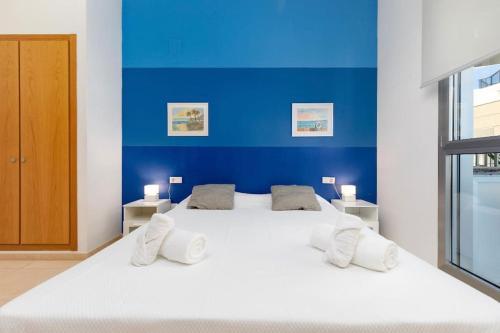 - une chambre avec un grand lit blanc et un mur bleu dans l'établissement luxury sea view apartment with 2 rooms, à Valence
