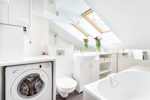 biała łazienka z pralką i umywalką w obiekcie Jacuzzi Kraków Bamboo w Krakowie