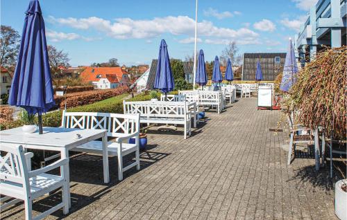 a row of tables and chairs with blue umbrellas at Two-Bedroom Apartment In Knebel in Knebel