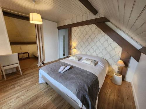 um quarto com uma cama grande num sótão em Logis Auberge des Aulnettes em Houlgate