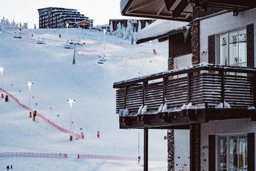 a snow covered ski slope with a ski lodge at Levin Alppitalot Alpine Chalets Deluxe in Levi