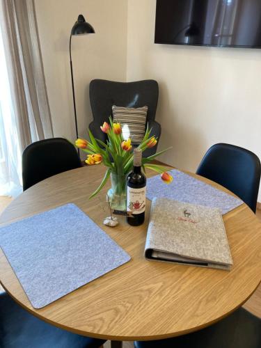 a wooden table with a bottle of wine and flowers on it at Ferienwohnung Einklang in Krün