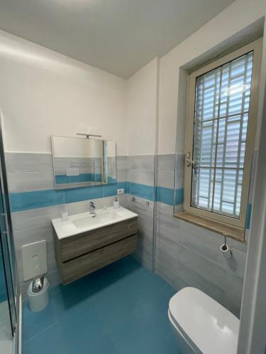 a bathroom with a sink and a mirror and a toilet at Merola Sisters Holiday Home in Caserta