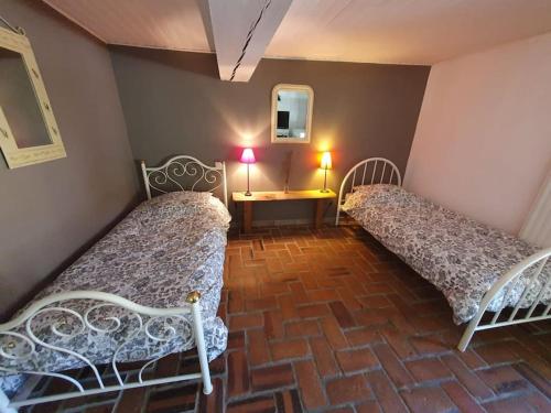 um quarto com duas camas e uma mesa com um espelho em Dépendance pour 1 à 4 pers au calme dans propriété em Marboz