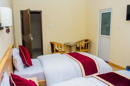 a room with two beds with red and white sheets at Amarapali Cottage and Restaurant Pvt. Ltd in Butwāl