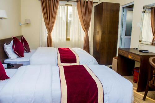 a hotel room with two beds and a desk at Amarapali Cottage and Restaurant Pvt. Ltd in Butwāl