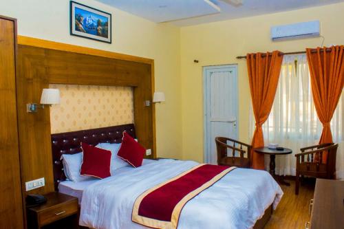 a bedroom with a large bed with red pillows at Amarapali Cottage and Restaurant Pvt. Ltd in Butwāl