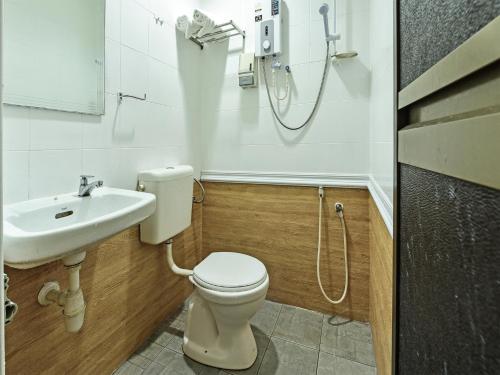 a bathroom with a toilet and a sink at Super OYO 44036 Hotel De Perdana Hill in Batu Pahat