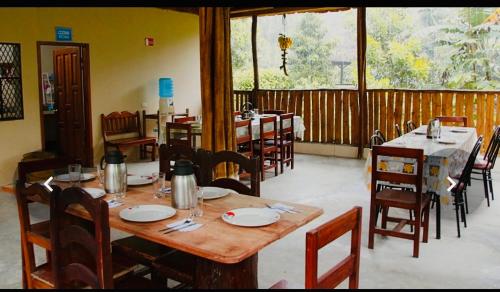 uma sala de jantar com mesas e cadeiras num restaurante em Candurumy Lodge em Tena