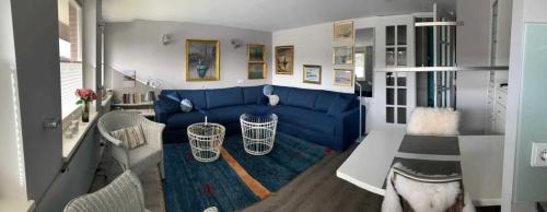 a living room with a blue couch and a table at Haus Friedeburg - Siilskep in Rantum