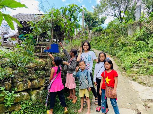 a woman and a group of children standing on a dirt road at Sa Moc - La Maison House & Bungalow in Sa Pa