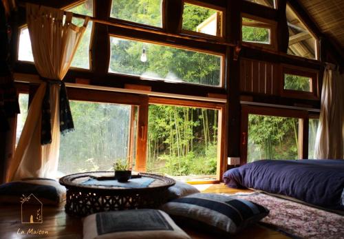 a bedroom in a tree house with a large window at Sa Moc - La Maison House & Bungalow in Sa Pa