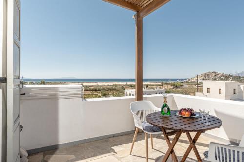 a balcony with a table and chairs and a view of the ocean at Zanneta Apartments & Suites in Mikri Vigla