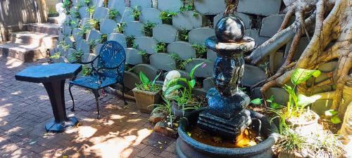 una fuente en medio de un jardín con sillas en Woodpecker on Marine, en Margate