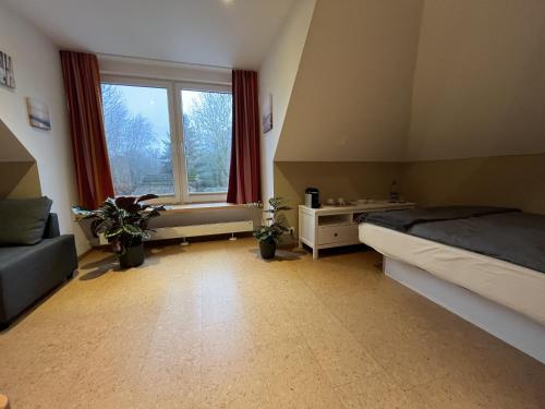 1 dormitorio con cama y ventana grande en Haus Kuestenperle en Schiffdorf
