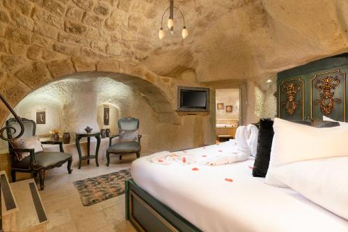 a bedroom with a large bed in a stone room at Elysion Cave Suites in Urgup