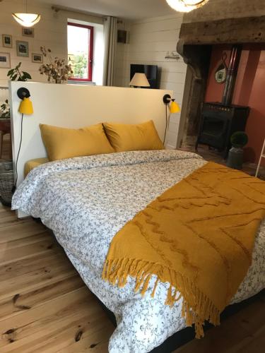 ein Schlafzimmer mit einem großen Bett mit gelben Kissen in der Unterkunft Maison à la campagne Les Oliviers in La Bruffière