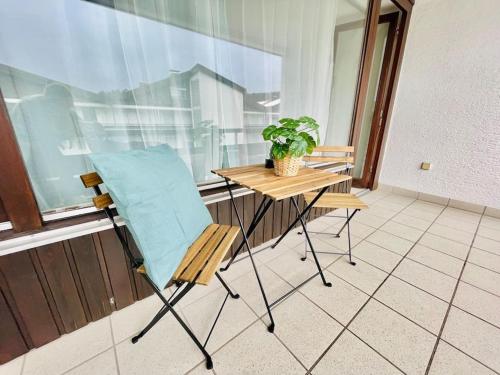 una silla y una mesa en una habitación con ventana en Allgäu Living - 46sqm, en Oberstaufen