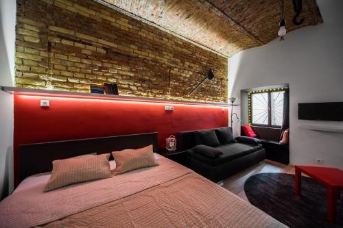 ブダペストにあるAranyos Apartman Budapestのレンガの壁、大きなベッド付きのベッドルーム1室