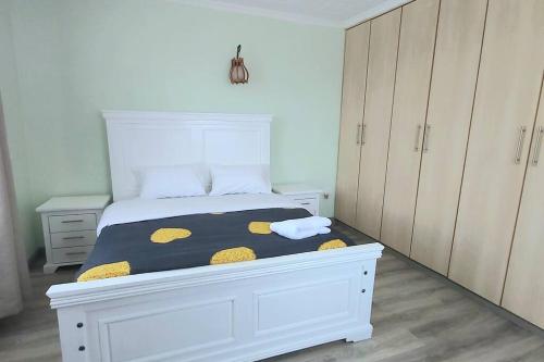 a bedroom with a white bed with a black and yellow blanket at Modern &homely guest suite w/free parking in Karen in Nairobi