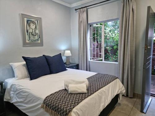 a bedroom with a large bed and a window at Tarrentoela selfcatering guesthouse in Kathu