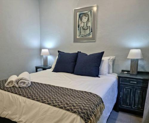 a bedroom with a large bed with blue pillows at Tarrentoela selfcatering guesthouse in Kathu