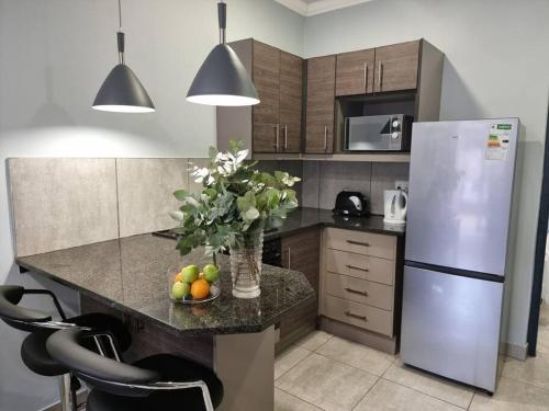 a kitchen with a refrigerator and a counter with fruit on it at Tarrentoela selfcatering guesthouse in Kathu