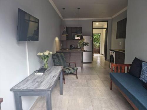 a kitchen and living room with a table and a couch at Tarrentoela selfcatering guesthouse in Kathu