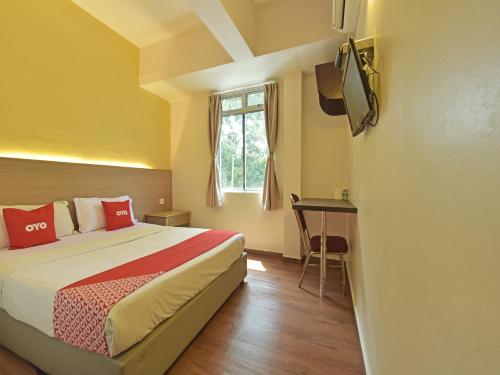Habitación de hotel con cama y TV en Super OYO 44036 Hotel De Perdana Hill, en Batu Pahat
