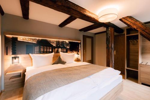 a bedroom with a large bed with white pillows at Hotel Einbecker Hof in Einbeck